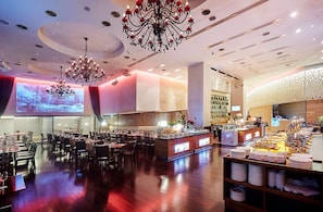A restaurant with a long counter, multiple chandeliers, and a projection screen. - Hotel Kukdo (Seoul)
