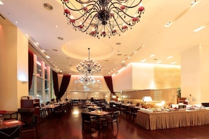 A spacious hotel dining area with multiple tables, a large chandelier, and a projection screen on the wall. - Hotel Kukdo (Seoul)