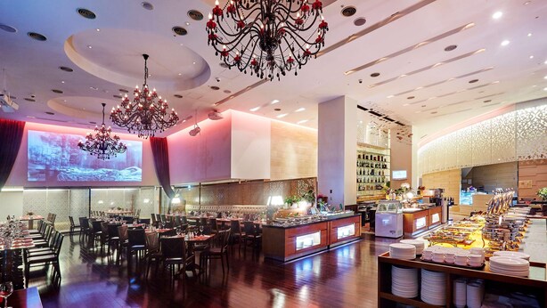 A restaurant with a long counter, multiple chandeliers, and a projection screen. - Hotel Kukdo (Seoul)