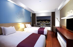 A hotel room with two beds, a desk, a TV, and a city view. - Hotel Kukdo (Seoul)