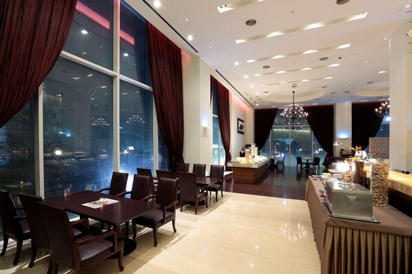 A hotel dining area with a long table, chairs, a buffet, and large windows with curtains. - Hotel Kukdo (Seoul)