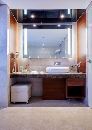 A modern bathroom with a large mirror, a white sink, a vanity, and a telephone. - Hotel Kukdo (Seoul)