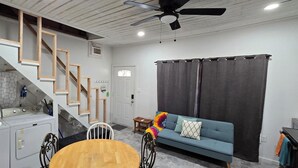 Ein kompakter Wohnraum mit Küche, Essbereich, Sofa und Treppe.