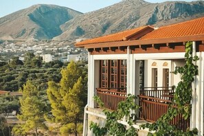 A building with a balcony, a red-tiled roof, and a mountainous backdrop. - Creta Maris Resort (Limenas Chersonisou)