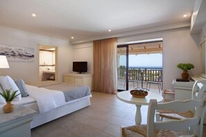 A hotel room with a bed, a TV, a balcony with a table and chairs, and a window with curtains. - Creta Maris Resort (Limenas Chersonisou)