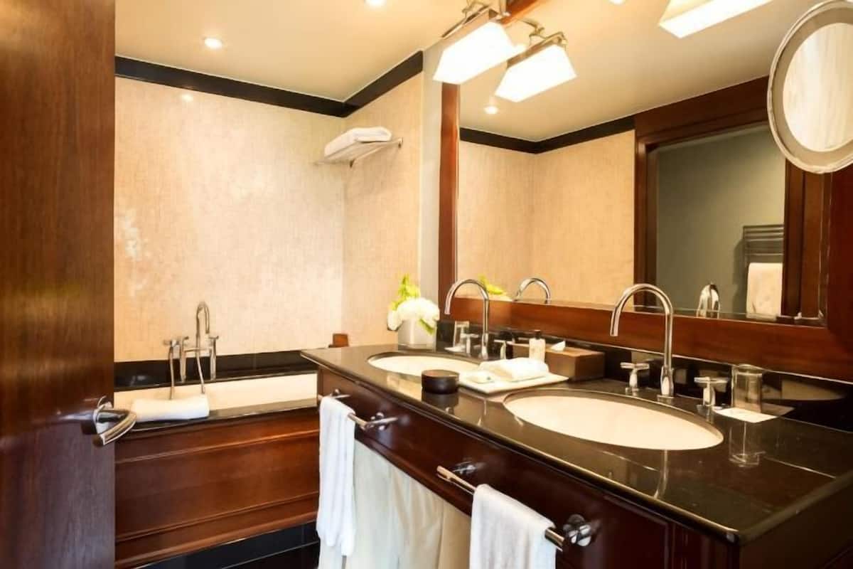 Un baño de hotel con dos lavamanos, un espejo grande y una ducha.