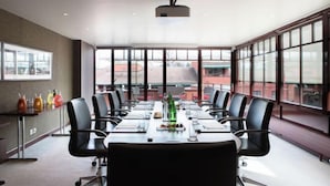 A conference room with a long table, black chairs, and a projector. - La Réserve Genève Hotel & Spa (Geneva)