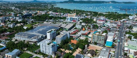 An aerial view of a coastal city with a mix of residential and commercial buildings, a marina with boats, and a large solar power facility.