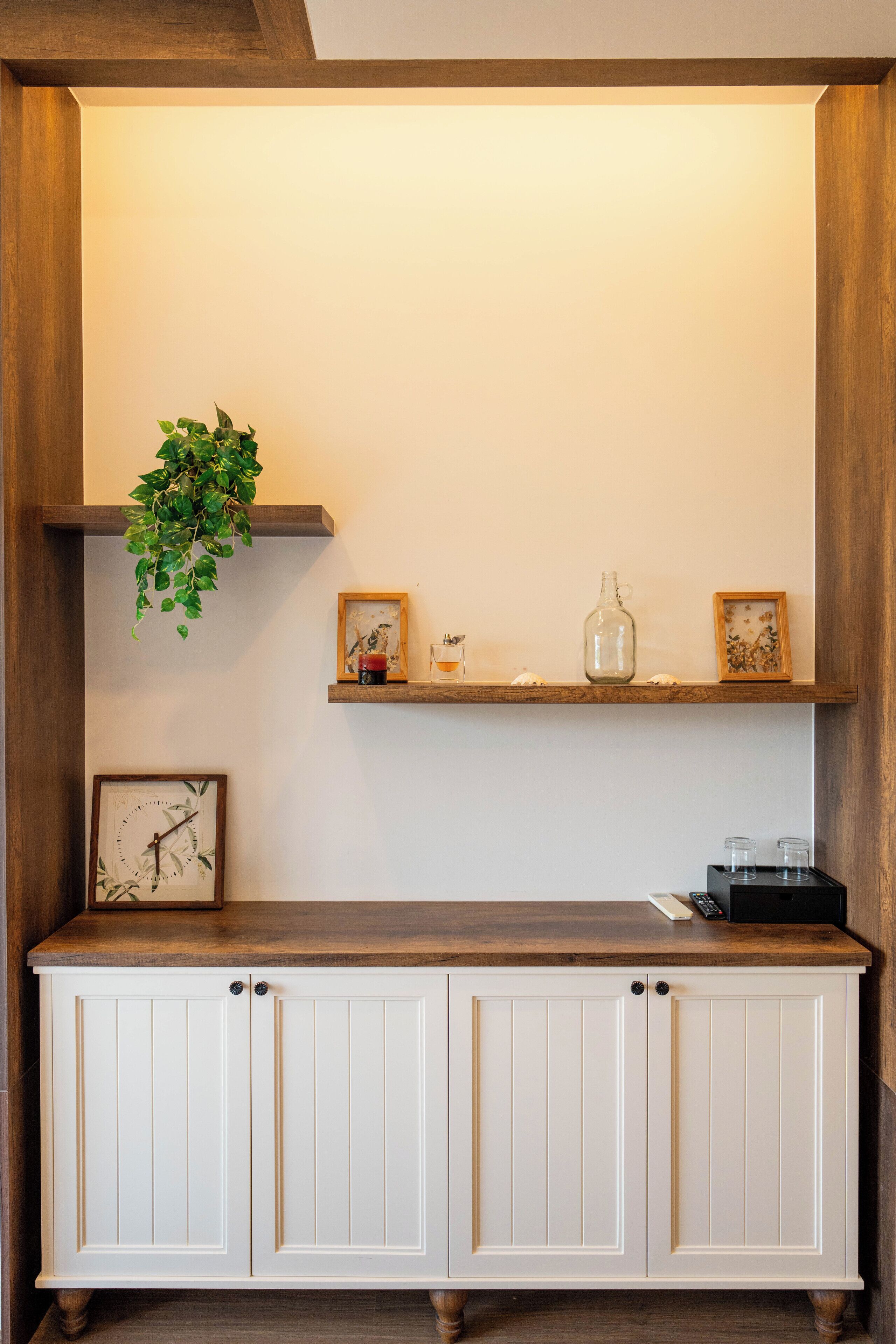 A wooden cabinet with two doors and a shelf above.