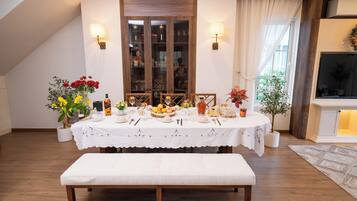 A dining area with a table set for a meal, a bench, and a cabinet with glass doors.