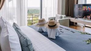 A modern hotel room with a large bed, a sofa, and a TV. - Sky Hill Villa Suratthani (Surat Thani)