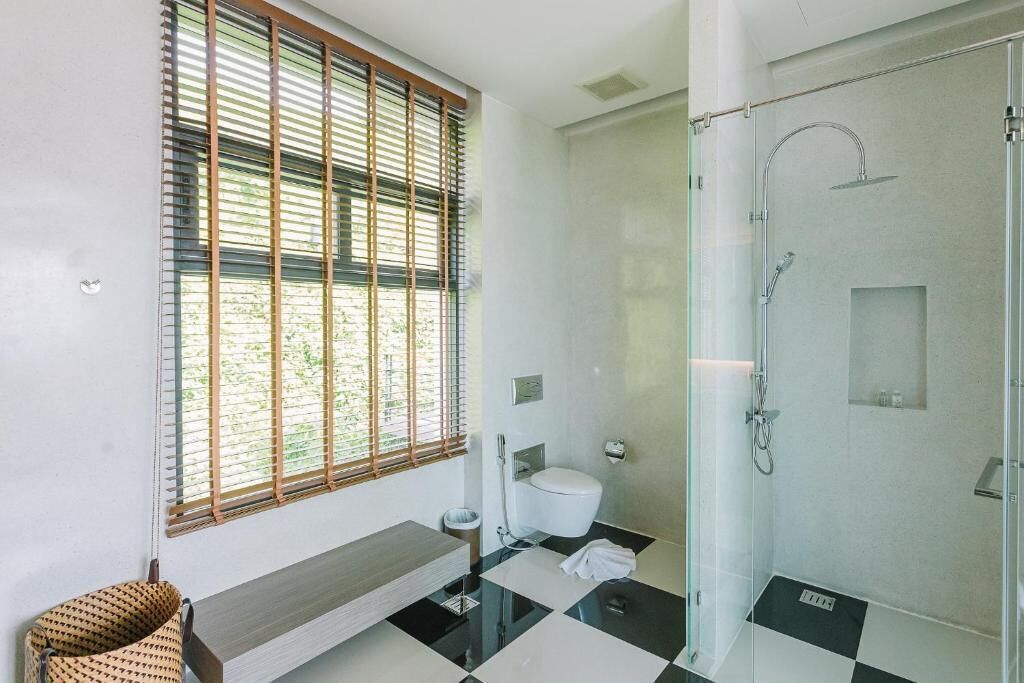 A modern bathroom with a toilet, bidet, and glass-enclosed shower.
