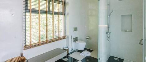 A modern bathroom with a toilet, bidet, and glass-enclosed shower.