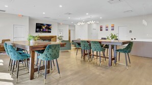 A modern dining area with wooden tables and teal upholstered chairs. - Chic 1-bed loft in Playhouse square, near Stadiums, Theater, Dining, Pets OK (Cleveland)