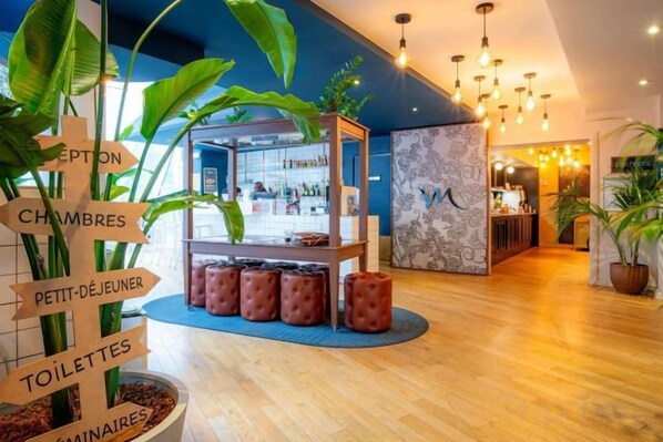 A hotel lobby with a reception desk, a signpost with room directions, and a bar area. - Mercure Paris Montparnasse Pasteur (Paris)