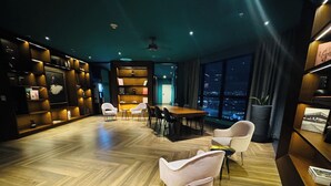 A modern interior with a wooden herringbone floor, a dining area with a table and chairs, and a large window with a city view. - Núcleo Sabana, San José, Apartment with A/C, 20 minutes from the Airport (San José)