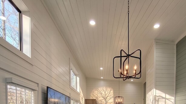 A spacious room with a large bed, a seating area, and a view of the outdoors. - Turquoise Triangle Tiny Homes (Cottonwood)