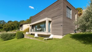 A modern two-story house with a flat roof, large windows, and a well-maintained lawn. - Villa Mondacce With Jacuzzi & Lake Views (Minusio)