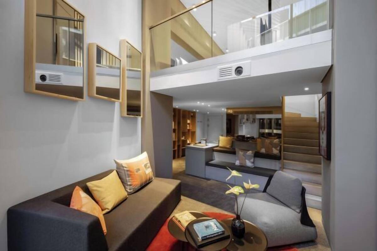 A modern living room with a sofa, a coffee table, and a bookshelf.