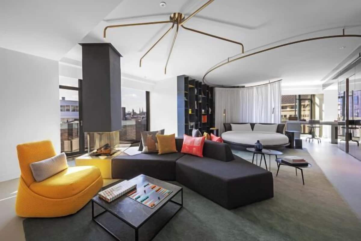 A modern living room with a sectional sofa, a coffee table, and a bookshelf.