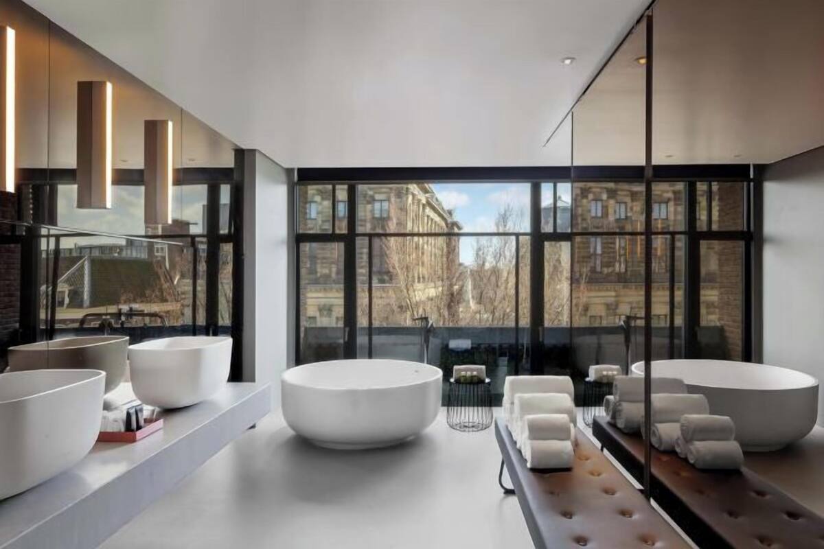 A modern interior with large windows, a central seating area, and a long counter with amenities.