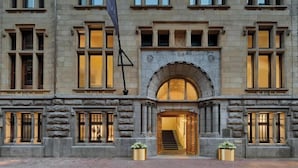 A large, historic building with a grand entrance, multiple windows, and a flag. - W Amsterdam (Amsterdam)