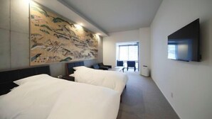 Une chambre d’hôtel avec deux lits, une grande fresque murale, un téléviseur à écran plat fixé au mur et une fenêtre laissant entrer la lumière naturelle.