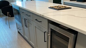 Eine moderne Küche mit Edelstahlgeräten, einer weißen Arbeitsplatte und einem eingebauten Backofen.