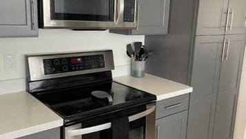 Een magnetron, een oven, een kookplaat, een vaatwasser