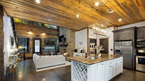 A spacious kitchen with a central island, built-in appliances, and a stone accent wall.