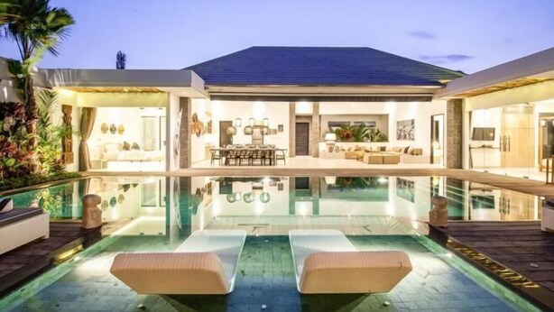 A modern house with a swimming pool, outdoor seating, and a well-lit interior. - Canggu PETER 2 (Bali)