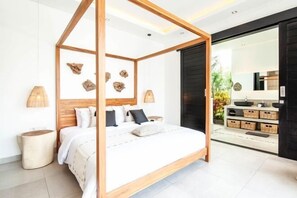 A modern bedroom with a four-poster bed, a wooden headboard, and a large mirror. - Canggu PETER 2 (Bali)