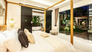A modern bedroom with a large bed, a glass door leading to a balcony, and a view of the outdoors. - Canggu PETER 2 (Bali)