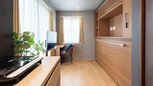A compact hotel room with a kitchenette, a dining area, and a large window with curtains. - D-WASEDA (Tokyo)