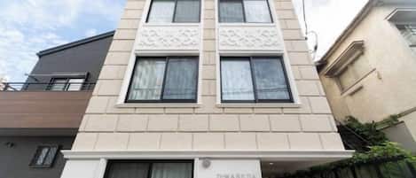 A multi-story building with a flat facade, large windows, and a sign indicating 'D-WASEDA'.