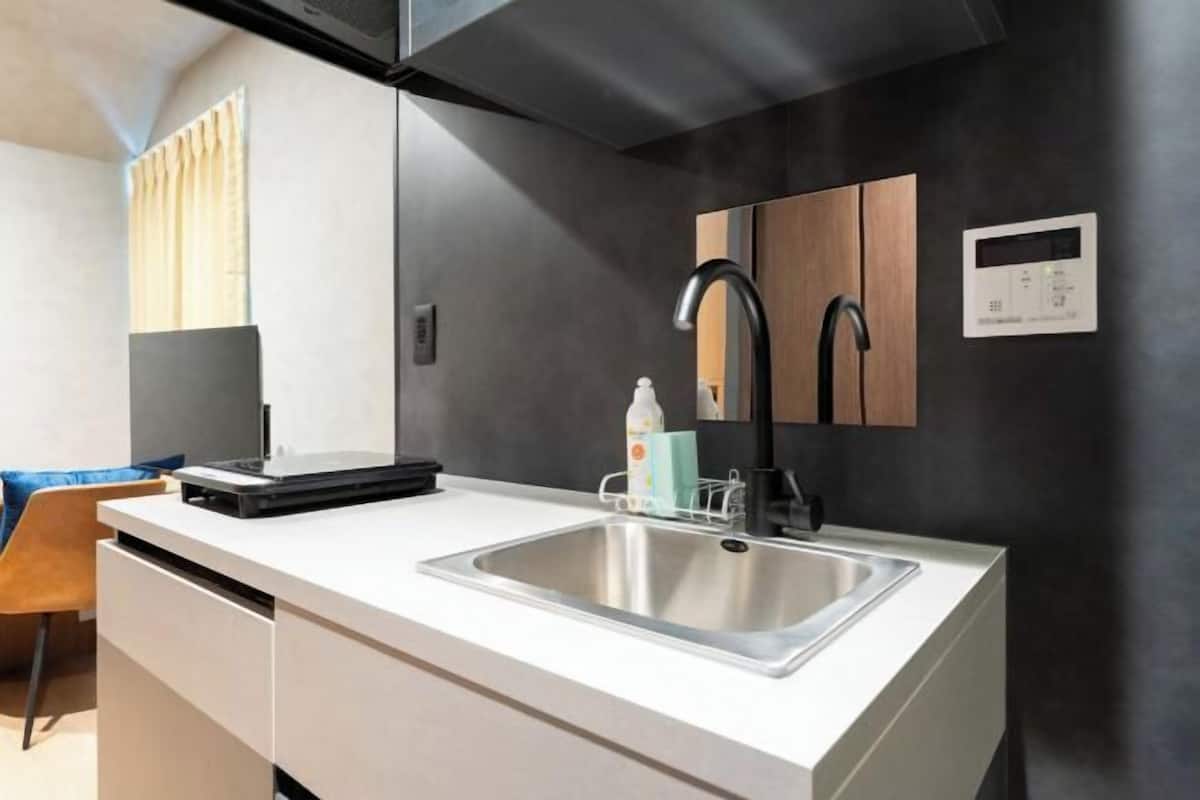 A modern kitchen with a stainless steel sink, a black faucet, and a built-in oven.