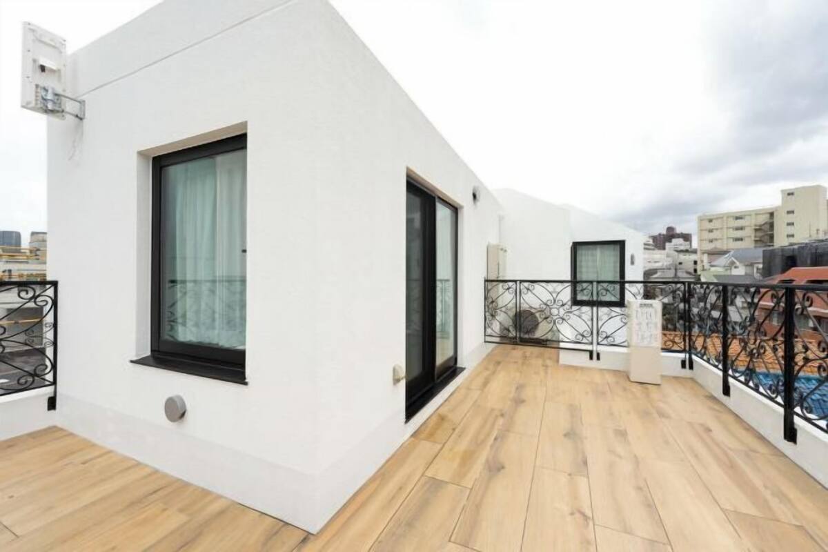 A modern apartment with a balcony, large windows, and a view of the city.