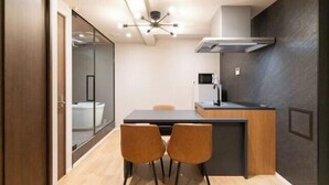 A compact kitchen with a central island, a microwave, and a modern faucet. - D-WASEDA (Tokyo)
