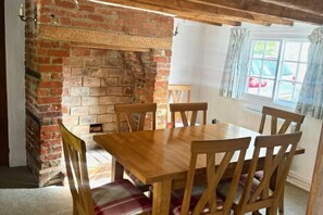 A dining area with a brick fireplace, wooden table, and chairs. - Memorial University of Newfoundland, Harlow Campus (Harlow)
