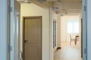 Un couloir avec une porte, un coin repas avec une table et des chaises, et des œuvres d’art accrochées au mur.