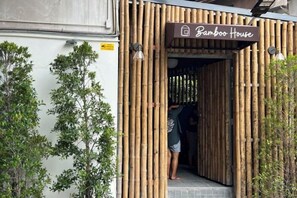 Una entrada de bambú a un edificio que dice 'Bamboo House'.