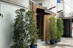 Un edificio con fachada de madera, un letrero y plantas en macetas.