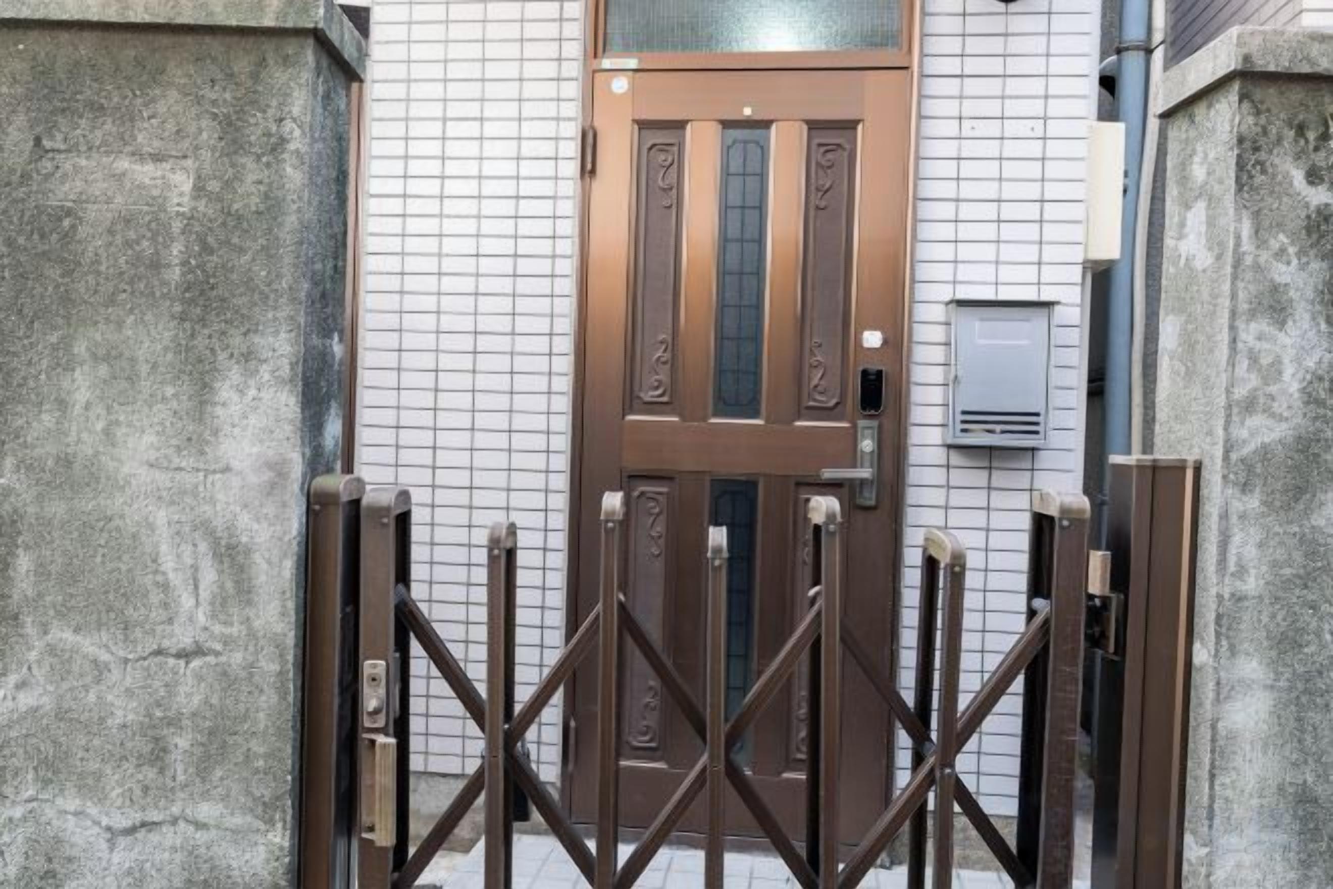 A gated entrance with a brown door and a metal gate.