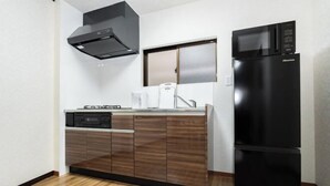 A compact kitchen with a built-in dishwasher, a microwave, and a refrigerator. - Kaike・Honcho detached house (Tokyo)