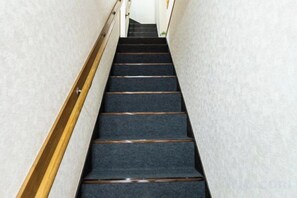 A carpeted staircase with wooden handrails and a white wall. - Kaike・Honcho detached house (Tokyo)