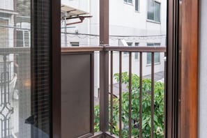 A balcony with metal railings, a view of a building, and some greenery. - Kaike・Honcho detached house (Tokyo)