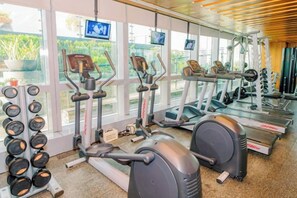 A gym with treadmills, elliptical machines, and weight equipment. - MCollection - Convenient City Stay in Iloilo Business Park (Iloilo City)