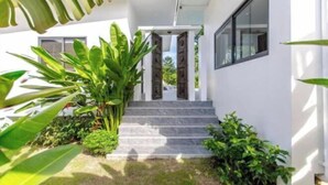 A modern house with a stone staircase leading to a wooden door. - Villa Lotus, 3 Bedrooms (Koh Samui)