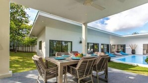 A modern outdoor dining area with a pool, wicker furniture, and a clear view of the pool. - Villa Lotus, 3 Bedrooms (Koh Samui)
