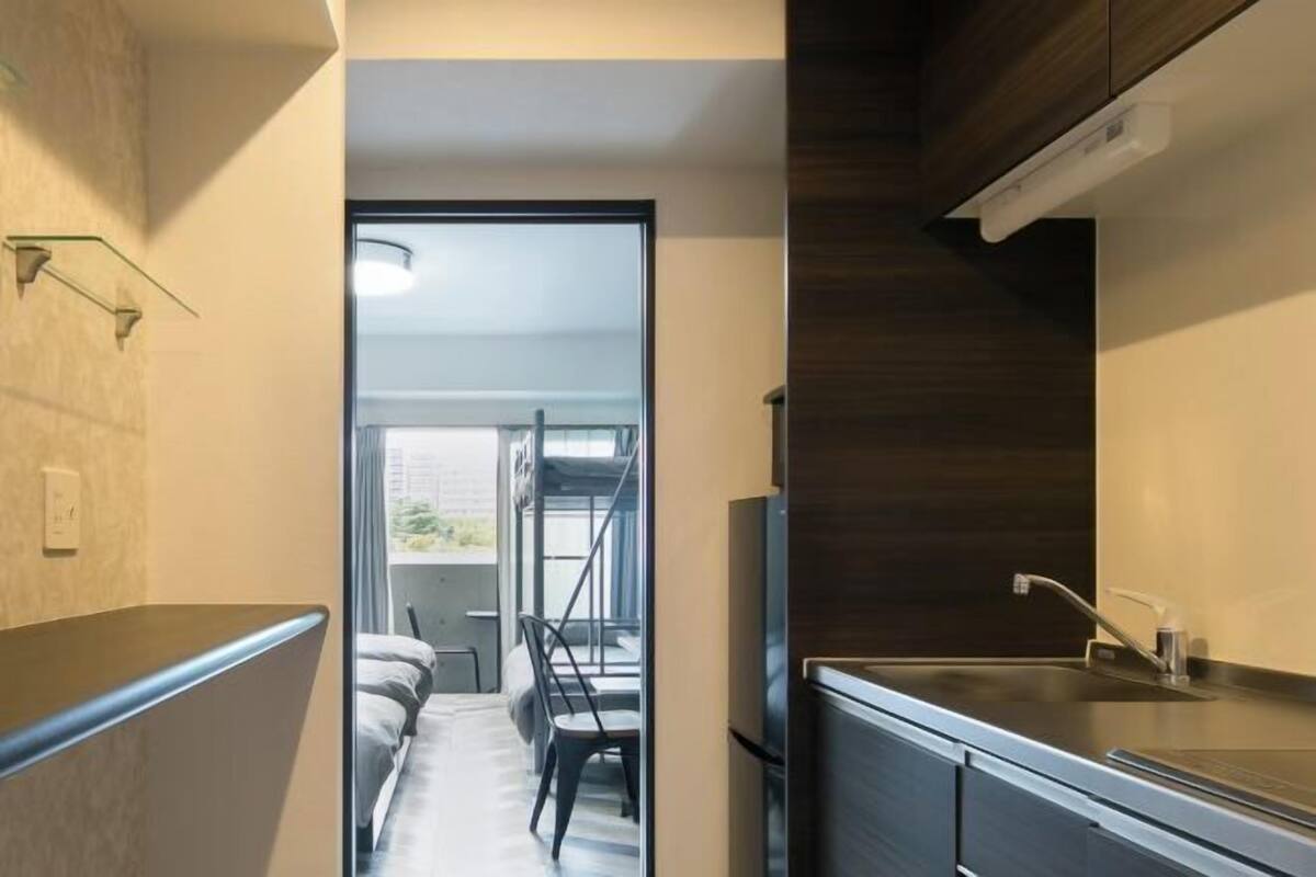 A modern kitchen with a built-in stove, a sink, and a window overlooking a balcony.